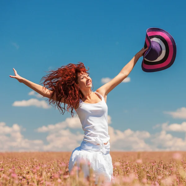 Mulher bonito correndo no campo com flores — Fotografia de Stock