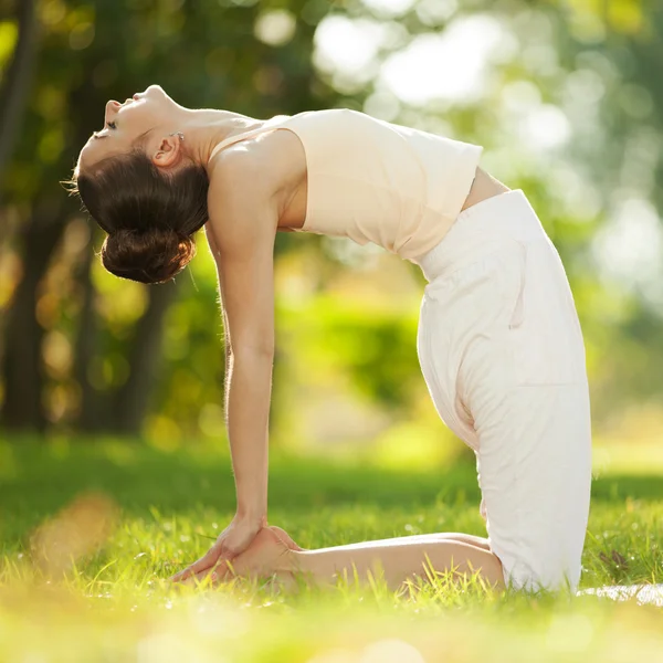 Jolie femme faisant des exercices de yoga dans le parc — Photo