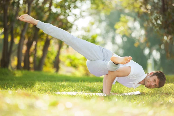 Adam parkta yoga egzersizleri yapıyor. — Stok fotoğraf