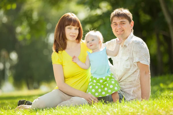 Lycklig familj. mor, far och dotter i parken — Stockfoto