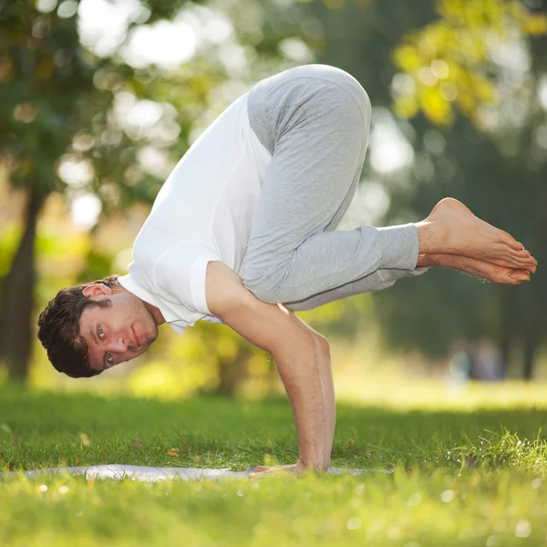 Adam parkta yoga egzersizleri yapıyor. — Stok fotoğraf