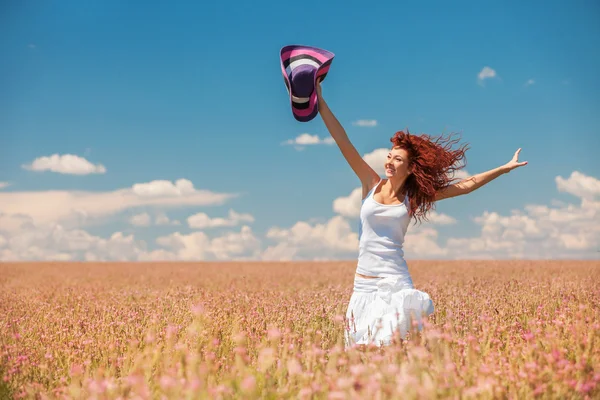 Cute woman running in the field with flowers — Stock Photo, Image