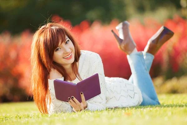 Jonge mooie vrouw met tablet in het park — Stockfoto