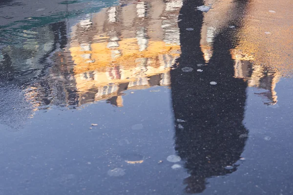 Reflection of man in puddle — Stock Photo, Image