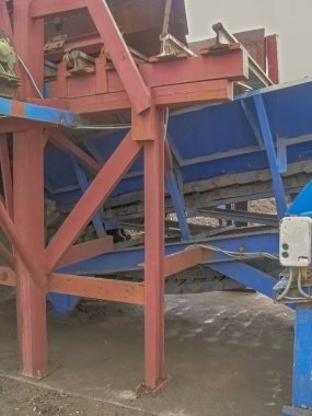 Metalurjik işleme kompleksinin teknolojik çizgisinin bir parçası olarak zincir apron taşıyıcı, yan görünüm 