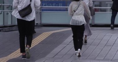 Şehirdeki sokakta yürüyen insanların yavaş çekimleri.