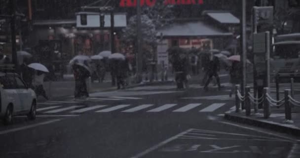 Shinjuku Tokyo 'da şehir caddesinde yürüyen insanlar el kamerasıyla kar yağıyor. — Stok video