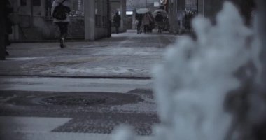Shinjuku Tokyo 'da şehir caddesinde yürüyen insanlar el kamerasıyla kar yağıyor.