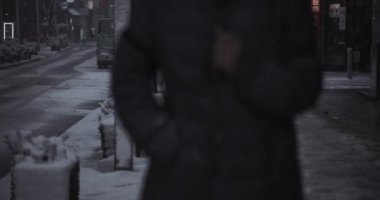 Shinjuku Tokyo 'da şehir caddesinde yürüyen insanlar el kamerasıyla kar yağıyor.