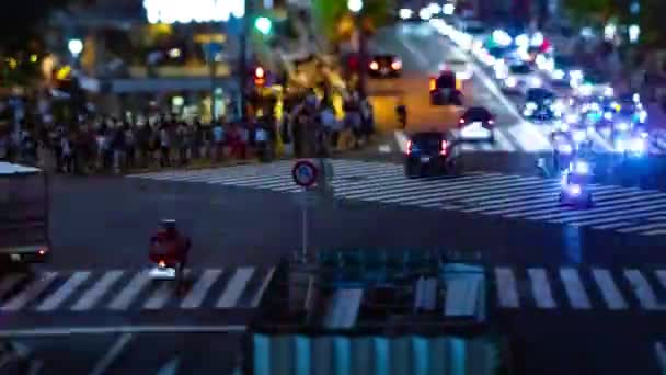 Een tijdspanne van de scramble kruising bij de neon stad in Shibuya Tokio tilt shift panning — Stockvideo