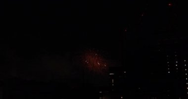 Yaz gecesi Tokyo 'daki şehir merkezindeki binanın yanında havai fişekler patladı.