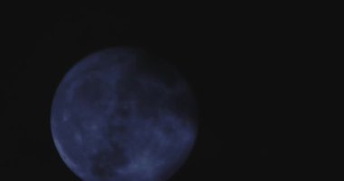 Karanlık bulutlu gece gökyüzünün arka planında bir dolunay