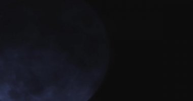 Karanlık bulutlu gece gökyüzünün arka planında bir dolunay