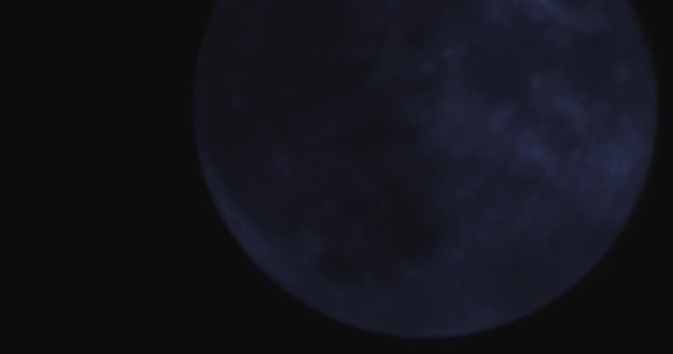Una luna piena su uno sfondo scuro cielo notturno nuvoloso — Video Stock