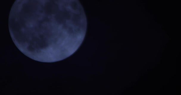 Karanlık bulutlu gece gökyüzünün arka planında bir dolunay — Stok video