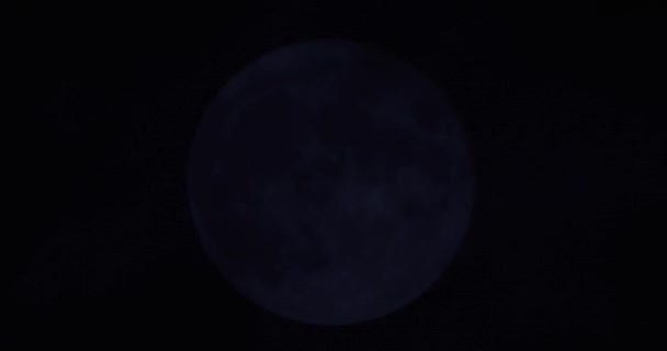 Una luna piena su uno sfondo scuro cielo notturno nuvoloso — Video Stock