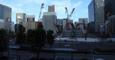 Tokyo 'daki binanın yakınındaki inşaat halindeki vinçler hareket ediyor.