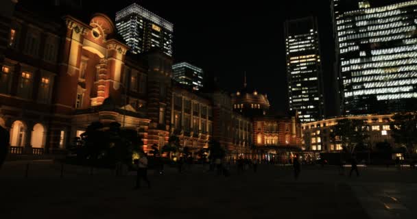 東京のビジネス街を歩く人々の夜の街並みワイドショット — ストック動画