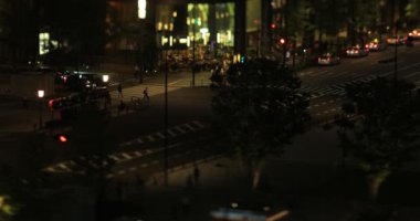 Tokyo 'daki iş kasabasında yürüyen kalabalık gece manzarası yüksek açıyı değiştiriyor.