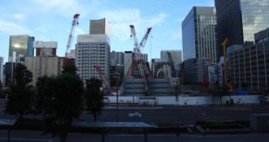 Tokyo 'daki binanın yakınındaki inşaat halindeki vinçler hareket ediyor.