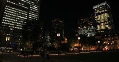 Tokyo 'daki iş kasabasında yürüyen insanların olduğu bir gece manzarası.