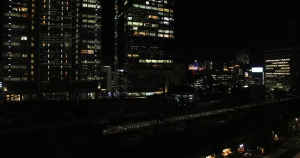 東京のビジネス街の駅の近くの夜の街並みが高い角度を持ちます — ストック動画