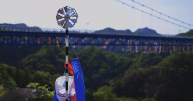 Ibaraki 'deki Ryujin Köprüsü' nde sazan balığı şeritleri. Gündüz güneşli, yakın çekim el kamerası.