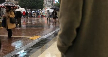 Tokyo yağmurlu bir günde Shibuya geçişinde yürüyüş insanlar