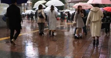 Tokyo yağmurlu bir günde Shibuya geçişinde yürüyüş insanlar
