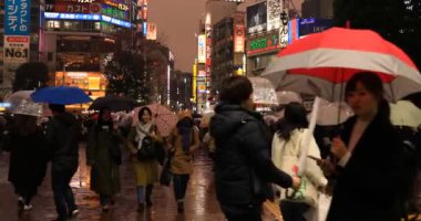 Tokyo yağmurlu bir günde Shibuya geçişinde yürüyüş insanlar