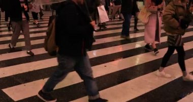 Tokyo yağmurlu bir günde Shibuya geçişinde yürüyüş insanlar