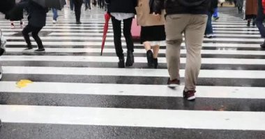Tokyo yağmurlu bir günde Shibuya geçişinde yürüyüş insanlar