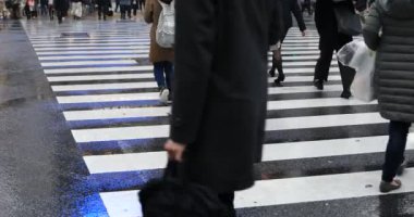 Tokyo yağmurlu bir günde Shibuya geçişinde yürüyüş insanlar