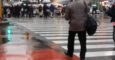 Tokyo yağmurlu bir günde Shibuya geçişinde yürüyüş insanlar