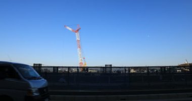 Yapım aşamasında geniş çekim de mavi gökyüzü arkasında hareketli vinçler