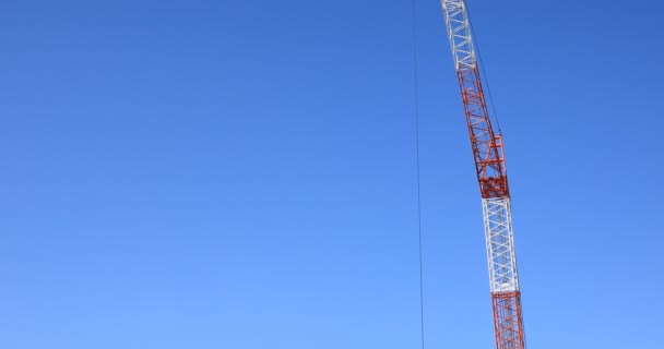 Flytta kranar bakom den blå himlen på under konstruktion — Stockvideo