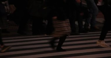 Shibuya geçidinde yürüyen insanların vücut parçaları gece