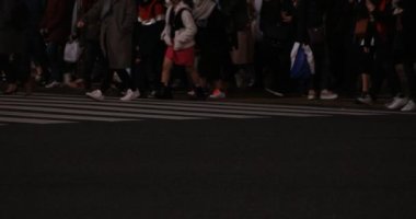 Shibuya geçidinde yürüyen insanların vücut parçaları gece