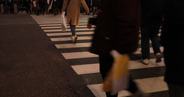 Прогуливая людей части тела на переходе Сибуя ночью — стоковое видео