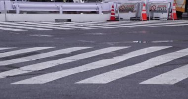 Shibuya 'da yağmurlu bir günde geçitte yürüyen insanların ağır çekimleri.