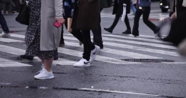Eine Zeitlupe laufender Menschen an der Kreuzung in Shibuya an einem regnerischen Tag — Stockvideo