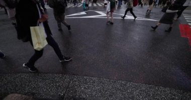 Shibuya 'daki kavşakta yürüyen insanların ağır çekim görüntüleri.