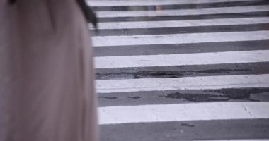 Shibuya 'da yağmurlu bir günde geçitte yürüyen insanların ağır çekimleri.