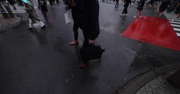 En slow motion av vandrande människor vid korsningen i Shibuya regnig dag bred skott — Stockvideo