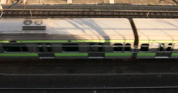 Проезд поезда по железной дороге в Токио днем вид сверху . — стоковое видео