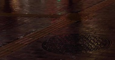Body parts of walking people on the street in Shinjuku at night rainy day handheld