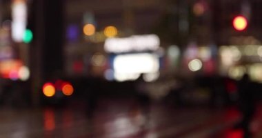 Defocused walking people on the street in Shinjuku at night rainy day handheld