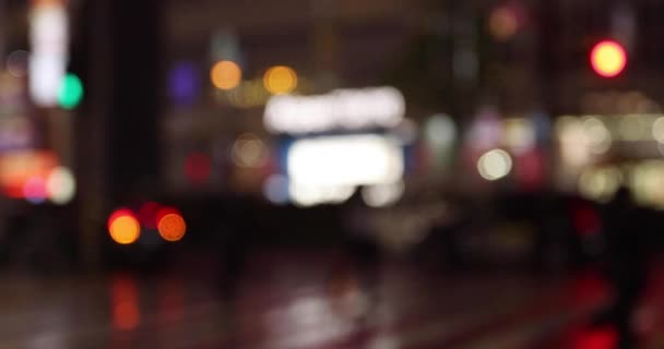 Verdorven wandelende mensen op straat in Shinjuku 's nachts regenachtige dag handheld — Stockvideo