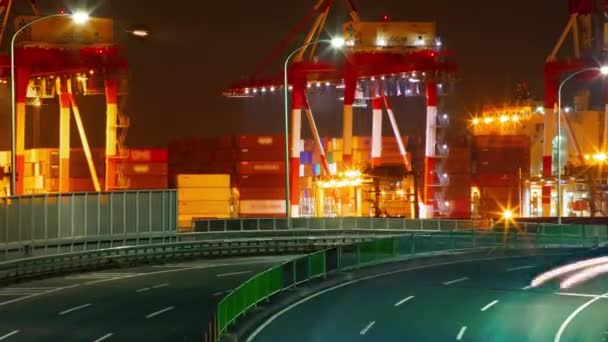 A night timelapse of logistic crane and traffic jam in Tokyo long shot zoom — Wideo stockowe