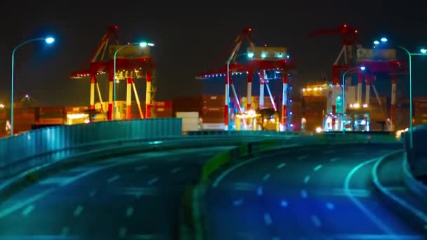 A night timelapse of logistic crane and traffic jam in Tokyo tiltshift tilting — стокове відео